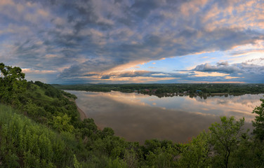 Evening thunderstorm over a wide river.