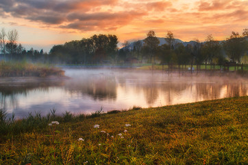 Fototapeta na wymiar Misty foggy morning sunrise on the Alpine lake