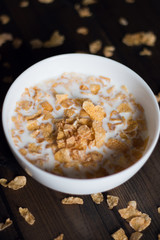 Corn flakes with milk on a wooden background