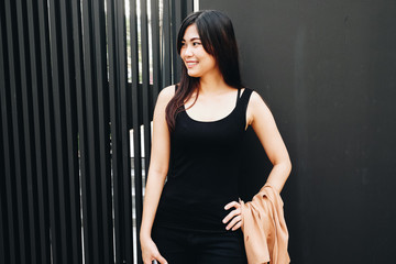 Asian women stand on modern building in black suit