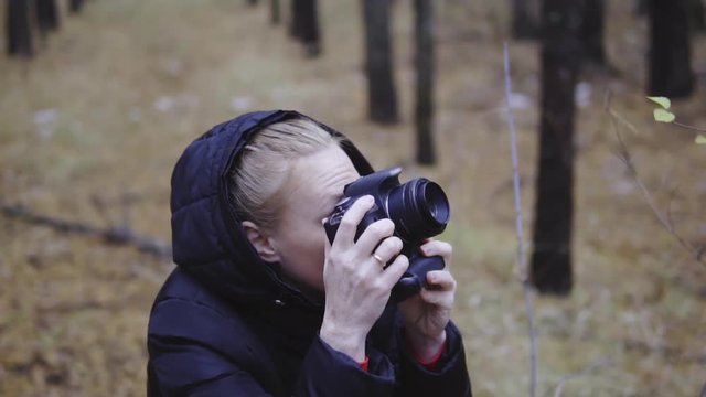 photographer traveler takes pictures of nature in the autumn forest. cinematic shot, slow-motion shooting.