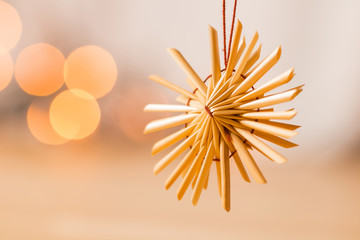 H&auml;ngender Strohstern - isoliert auf weichem Lichter Hintergrund