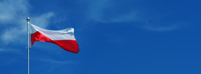 Polish, white and red flag waving against the blue sky