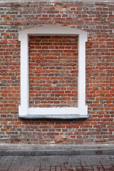 Walled window with white pebbles in an old brick wall