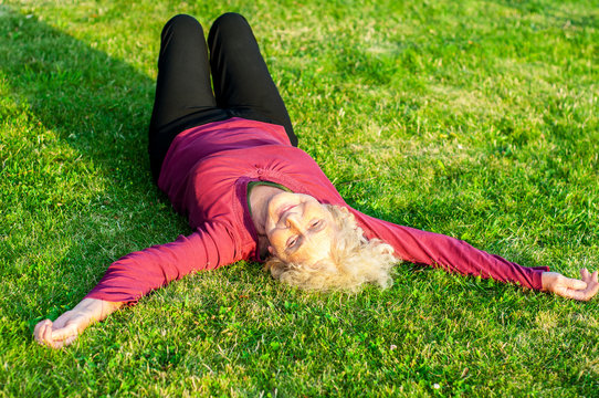 The older woman lies on the lawn