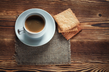 Coffee cup and cookie on wood