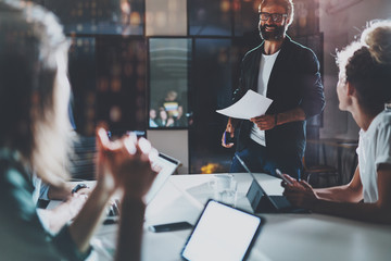 Business people brainstorming concept photo.Coworkers working at night office.Horizontal, flares effect.Blurred background.