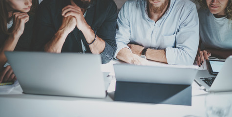 Group of young entrepreneurs using mobile gadgets for looking a business solution during work...