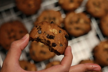 hold a cookie chocolate bean with fingers blur cookies background