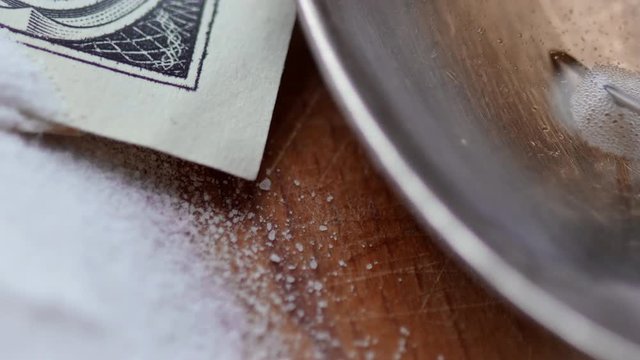 Money, drug, spoon and syringe with heroine on a table. 4K UltraHD video footage