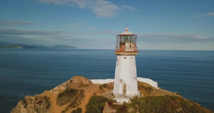 Beautiful aerial panoramic and zooming out view of the lighthouse Brinera, situated on the rocky cliff. Great seashore (sea of Japan) is on the background. Far East of Russia