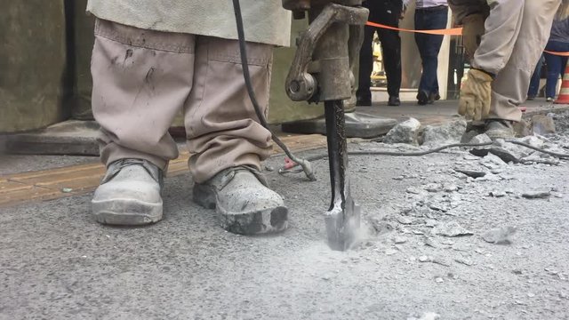 Building demolition jack hammer drill breaking concrete. City construction