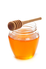 glass jar full of honey and dipper