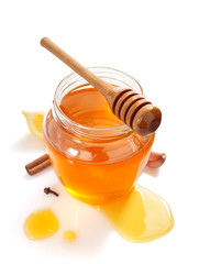 glass jar full of honey and dipper