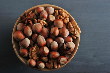 Nuts in bowl - hazelnut in shell, peeled walnuts, anise