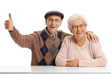 Elderly man and an elderly woman with the elderly man holding his thumb up