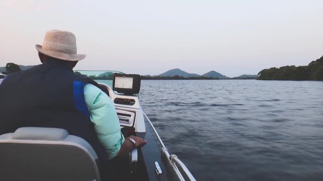 Fisherman navigating on his boat on morning on a river in Pantanal - Brazil. 