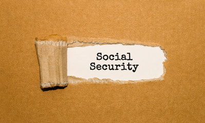 The text Social Security appearing behind torn brown paper