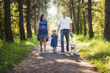 Happy family with dog walking in the Park