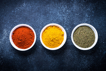 Various spices in a bowls on stone table.