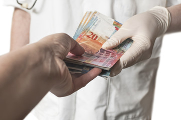  Doctor receiving large amount of Swiss banknotes as a bribe.