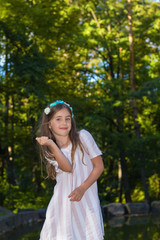 Cute little girl making funnie faces in the city park in the summer time