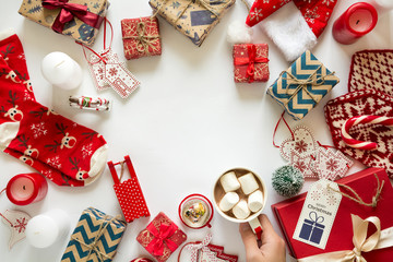 Christmas background with handmade presents wrapped in craft paper, cup of hot chocolate. Flat lay. Space for copy