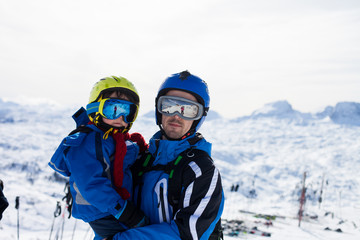 Fototapeta na wymiar Father and son, skiing happily in Austrian ski resort in the mountains