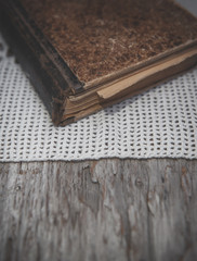 Vintage old book and lace fabric on the old wooden background