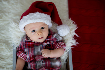 Christmas portrait of cute little newborn baby boy, dressed in christmas clothes