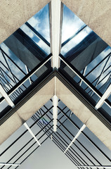 Fototapeta premium Urban Geometry, looking up to glass building. Modern architecture black and white, glass and steel. X marks the spot. Abstract architectural design. Inspirational, artistic image BW.