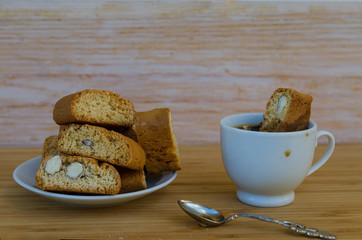 Homemade biscotti cantuccini or cantucci, typical Italian almond sweets biscuits or cookies and cup of espresso coffee on wooden table.Copy space.