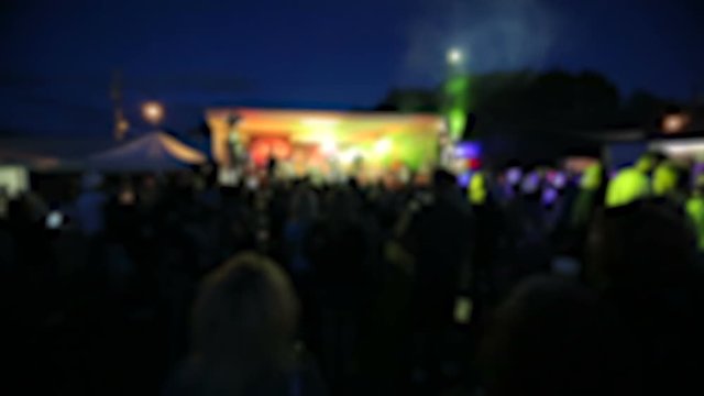 Band on Stage at Outdoor Festival Crowd Blur. a blurred shot of a band and crowd during a performance at a festival outside with light show
