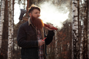 Obraz na płótnie Canvas a woodcutter smokes an electronic cigarette after work