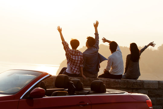 Young men and women travel by car