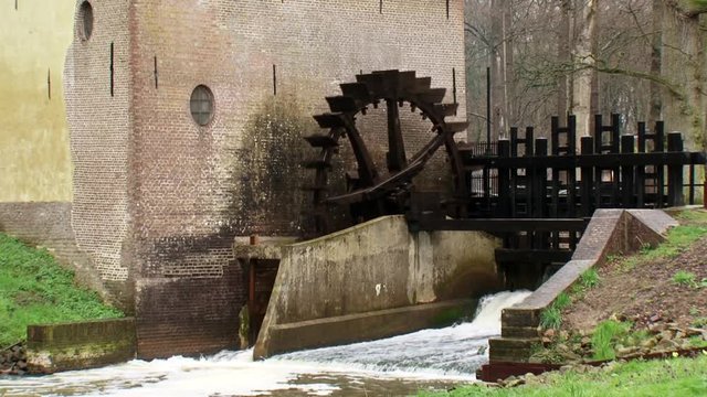 Ancient water mill with an undershot water wheel on the Baakse Beek at Hackfort estate.HACKFORT, THE NETHERLANDS - APRIL 2016: 