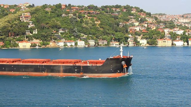 Bulk Carrier Ship with water flowing from hawse pipe, sails into the Bosphorus Sea, Istanbul. A 229 mt long, 32 meter width vessel, has a deadweight of 80,500 tons. High Angle View, Static Shot
