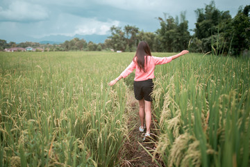 Young lady runing with tissue in green field.