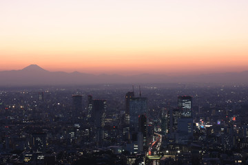 Fototapeta na wymiar 日本の東京都市景観・都心から望む富士山。太陽が沈んだあともシルェツトが浮かび上がった（手前は、渋谷のビル群など）