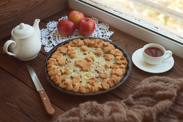 Apple tart with cup of tea and whole apples
