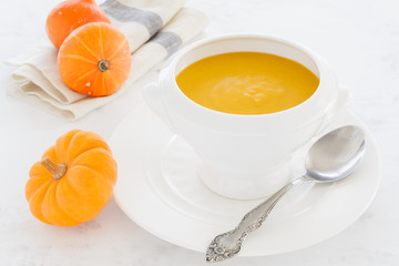 vegetable orange soup with parmesan cheese, bacon, mushrooms in a white deep soup plate. soup macro