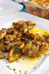 French traditional dish frog paws with parsley and garlic top view. gastronomic dish of French cuisine