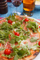 Italian pizza with ham, cherry tomatoes, arugula, mozzarella buffalo cheese. food background with selective focus
