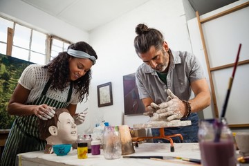 Woman and man learning pottery in class - obrazy, fototapety, plakaty