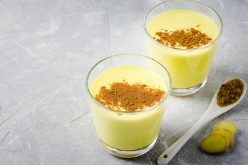 Turmeric cinnamon golden milk drink on stone background. Selective focus, space for text. 