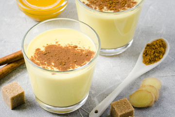Vanilla cinnamon turmeric tea latte on stone background. Selective focus, space for text. 