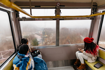 Tourists sit in Usuzan Ropeway for going down from Mount Usu in winter in Hokkaido, Japan. - obrazy, fototapety, plakaty