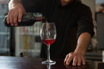 Waiter pouring wine in the glass