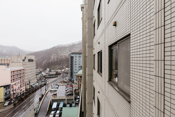 Cityscape with trees and mountain with snow on it in the morning in Hokkaido, Japan.