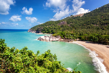 Tropical beach and hills covered with palm trees, view from the top